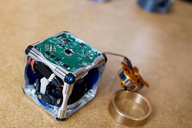 A prototype of a new modular robot, with its innards exposed and its
flywheel — which gives it the ability to move independently — pulled out.