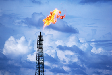 flame at the top of a gas flare tower
