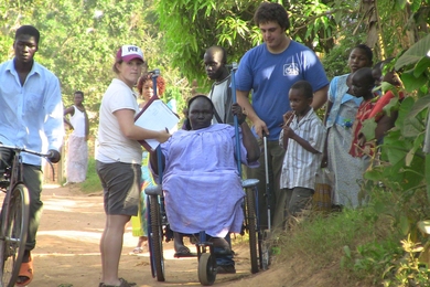 MIT Assistant Professor Amos Winter (right, blue shirt) and Tish Scolnik ’10 were inspired to build a more rugged wheelchair after visits to Tanzania.