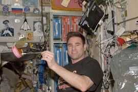 NASA Astronaut Greg Chamitoff PhD '92 catches a meal near the galley of the International Space Station. Michael Fincke '89 will be joining him shortly.