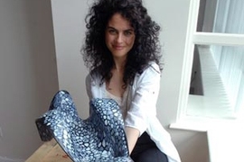 Neri Oxman poses in her studio with a model of a molded chaise longue that drew inspiration from the internal structure of bones and other biological forms.