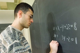 Avinatan Hassidim, a postdoc in the Research Laboratory of Electronics, writes out a system of four linear equations with four variables. The quantum algorithm that he, Seth Lloyd, and Aram Harrow devised can solve systems with a trillion equations and a trillion variables.