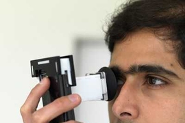 Postdoctoral Associate Ankit Mohan demonstrates NETRA (Near-Eye Tool for Refractive Assessment). The user places the device to the eye and, using phone's keypad, aligns patterns in the viewfinder. These alignments provide the data needed to determine a prescription.
