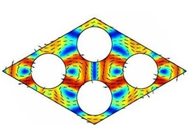 A computer simulation shows phonons, depicted as color variations, traveling through a crystal lattice. The lattice in this case is broken up by round rods whose spacing has been chosen to block the passage of phonons of certain wavelengths.