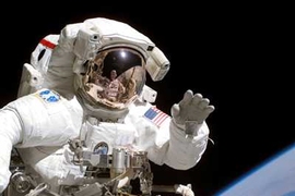 Astronaut Joseph R. Tanner, STS-115 mission specialist, waves at the camera during a space walk.