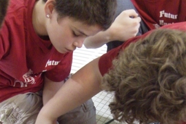 Students work on a Sea Perch ROV poolside