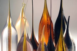 Samples of materials that have been made into fibers in the lab of MIT’s Yoel Fink. The initial material is made into a 'preform,' in the lower portion, which is then heated and drawn out like taffy into a fiber from the top, preserving the arrangement of materials within the structure.