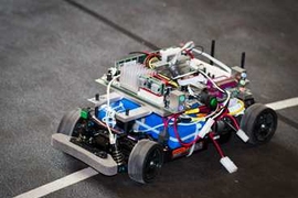 The researchers test their algorithm using a miniature autonomous vehicle traveling along a track that partially overlaps with a second track for a human-controlled vehicle, observing incidences of collision and collision avoidance.