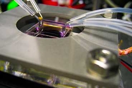 Zinc oxide nanostructures are directly synthesized in parallel microfluidic channels (held by the metal frame) by flowing reactants through the tubing. The microfluidic structure not only creates the device, but also becomes the final packaged functional LED device itself.