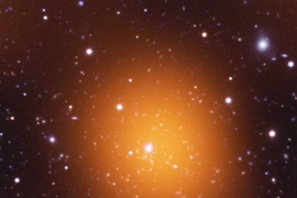 Microwave (orange), optical (red, green, blue) and ultraviolet (blue) image of the Phoenix Cluster.