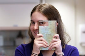 Shannon Taylor holds up an ingot, which is 30 percent by weight copper and 70 percent by weight silver, which is similar composition to some artifacts she studies.