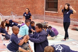 MITxplorers build skyscrapers with spaghetti and marshmallows under the encouragement of co-president and mentor Debbie Nguyen (right).