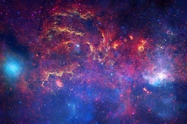 This composite image combines observations using infrared light and X-ray light that see through the obscuring dust and reveal the intense activity near the galactic core.