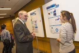Eric Grimson, MIT chancellor for academic advancement, talks with Rose Abramson, '15, about her work with Jesus del Alamo, director of the Microsystems Technology Laboratories, on developing transistors made with silicon alternatives and sized below 10 nanometers.