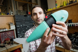 Andrew Marchese, doctoral candidate in EECS, holds a soft robotic fish developed by the Distributed Robotics Laboratory.
