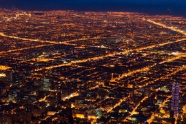 Aerial photo of a city at night, very lit up with lights