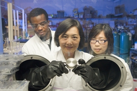 Yang Shao-Horn (center), professor of mechanical engineering and materials science and engineering at MIT, examines an experimental lithium-air battery with graduate students Yi-Chun Lu (right) Koffi Pierre Claver Yao.