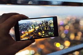 hand holding a smartphone with city lights on the screen