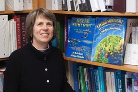 MIT Institute Professor Sallie (Penny) Chisholm poses with the first two books in the “Sunlight Series,” a collection of children's books that teach Earth's natural processes from the point of view of the sun. 