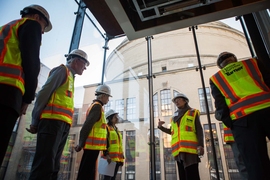 MIT Professor Krystyn Van Vliet (center) describes how MIT.nano clean rooms will provide a precisely controlled environment. MIT Corporation members Gregory Turner (second-from-left) and Madeleine Gaut (third-from-left) listen along with Anuradha Agarwal (fourth-from-left), a principal research scientist at the MIT Microphotonics Center. 