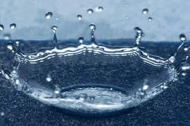 Droplets that land on a specially prepared surface with tiny ring-shaped patterns splash upward in a bowl shape, as seen in this photo, instead of spreading out over the surface, thus minimizing the water’s contact with the surface.