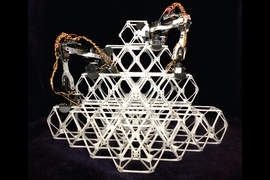 Photo shows two prototype assembler robots at work putting together a series of small units, known as voxels, into a larger structure.