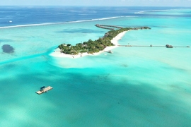 In the lower left corner of this photograph, researchers prepare a submersible device. “Together with our collaborators in the Maldives, we are designing, testing, building, and deploying submersible devices that, based simply on their geometry in relationship to the ocean waves and currents, promote sand accumulation in specific areas,” says associate professor Skylar Tibbits.