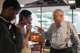 Photo of Bill Hecht teaching how to tie a bow tie