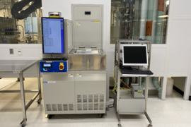 Photo of MIT.nano’s reactive-ion etching system, a large metal box several feet wide and perhaps 5 feet tall, with an attached monitor as well as a separate computer and keyboard on a wheeled tray