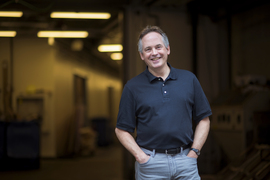 Photo of Brian LaBombard, wearing jeans and a navy polo shirt and standing with his hands in his pockets