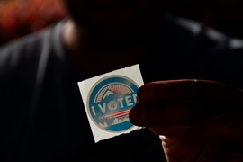 Photo of a person holding "I voted" sticker