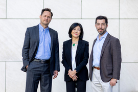 Portrait of Hugh Herr, Lisa Yang, and Ed Boyden standing in front of a building with large white tiles on the facade