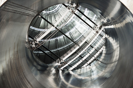 The interior of the KATRIN main spectrometer, a shiny silver, mainly spherical structure, with the field shaping wire electrodes in view.