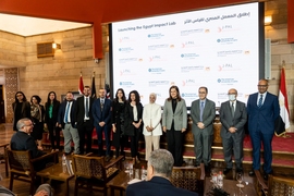 Photo of 13 people lined up in front of a screen of information in English and Egyptian