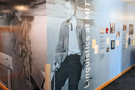 Photo of a corner that features black and white photos of young Morris Halle and Noam Chomsky, along with other artifacts. The wall is labled "Chomsky | Halle Wing, MIT Linguistics"