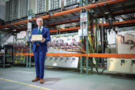 Photo of Donald Sadoway posing with his award in front of a large bank of electronics