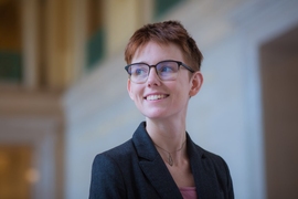 Amelia Trainer in an MIT building lobby, with background in soft focus