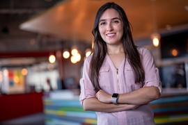 Jennifer Madiedo poses for the camera in a room that's blurred in the background