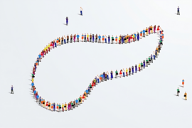 Drawing of a large group of people from an aerial perspective forming a distorted oval shape. Several individuals are standing apart from the formation.