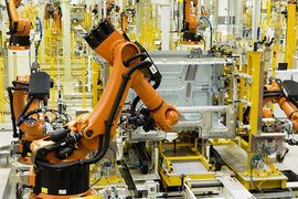 Multiple robotic arms working in close proximity inside a warehouse setting