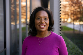 Deborah Liverman stands in front of a glass building
