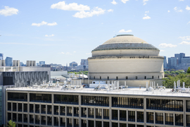 Aerial view of the MIT Dome with Building 13 in front and Boston skyline in the distance