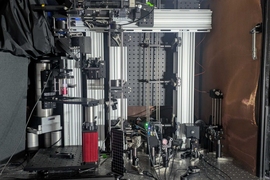 A microscope system comprising a complicated assemblage of optical, electronic, and other equipment atop a metal table
