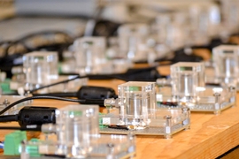 Rows of small glass-and-metal items on a wooden table