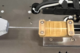 A wooden piece attached to a fiber stretching