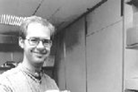 Graduate student Mark Ottensmeyer displays the latest version of PHANToM. Depending on which wall of the square represented on the computer screen one "touches" with the PHANToM, the sensation of hot, cold or a neutral temperature will be felt by the user.