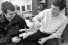 Mechanical engineering sophomore Ben Powers (left) shows his Stirling engine, polished to a shiny hue and the first to be completed and work well, to Associate Professor Douglas Hart, who oversaw the IAP activity in which students built the engines.