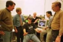 Members of the Center for Space Research working on the virtual-reality display system for the International Space Station are (left to right) Rick Foster; Dr. Charles Oman, head of the Man Vehicle Lab; Matt Smith (wearing the virtual-reality headset); Jim O'Connor; Andy Liu and Bob Goeke. (All but Dr. Oman are sponsored research technical staff.) On the monitor is the inside hallways of the space...