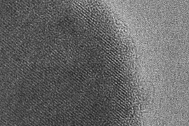 Scanning electron micrograph of a particle of the new battery material. Dark area indicates the inside of the particle surrounded by a lighter surface layer only five nanometers wide.