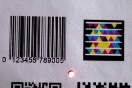 The Bokode device, at center, is much smaller than other types of
barcodes, yet can contain far more information.